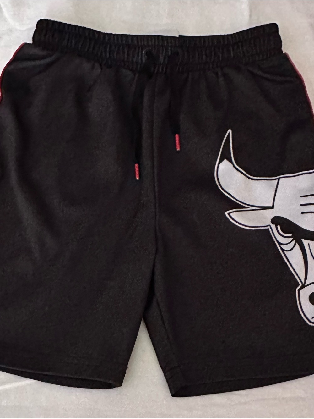 NBA kids Black Athletic Shorts with White Bull Graphic and Red Trim